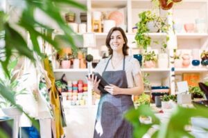 Smiling shop owner standing in a plant-filled store