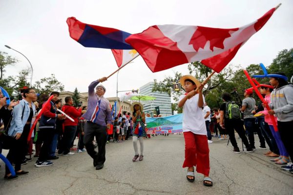 People waving Canada and Philippine flags