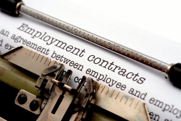 Employment contracts on a desk, symbolizing ethical recruitment practices in Qatar.