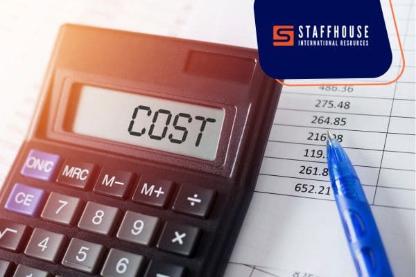 Calculator showing cost with pen and document.