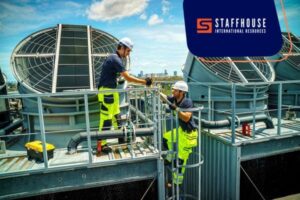 Engineers working on industrial cooling system outdoors.