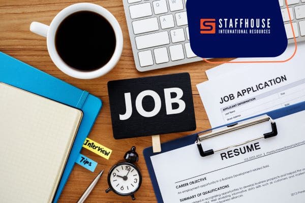 Job application documents with resume and coffee on desk.
